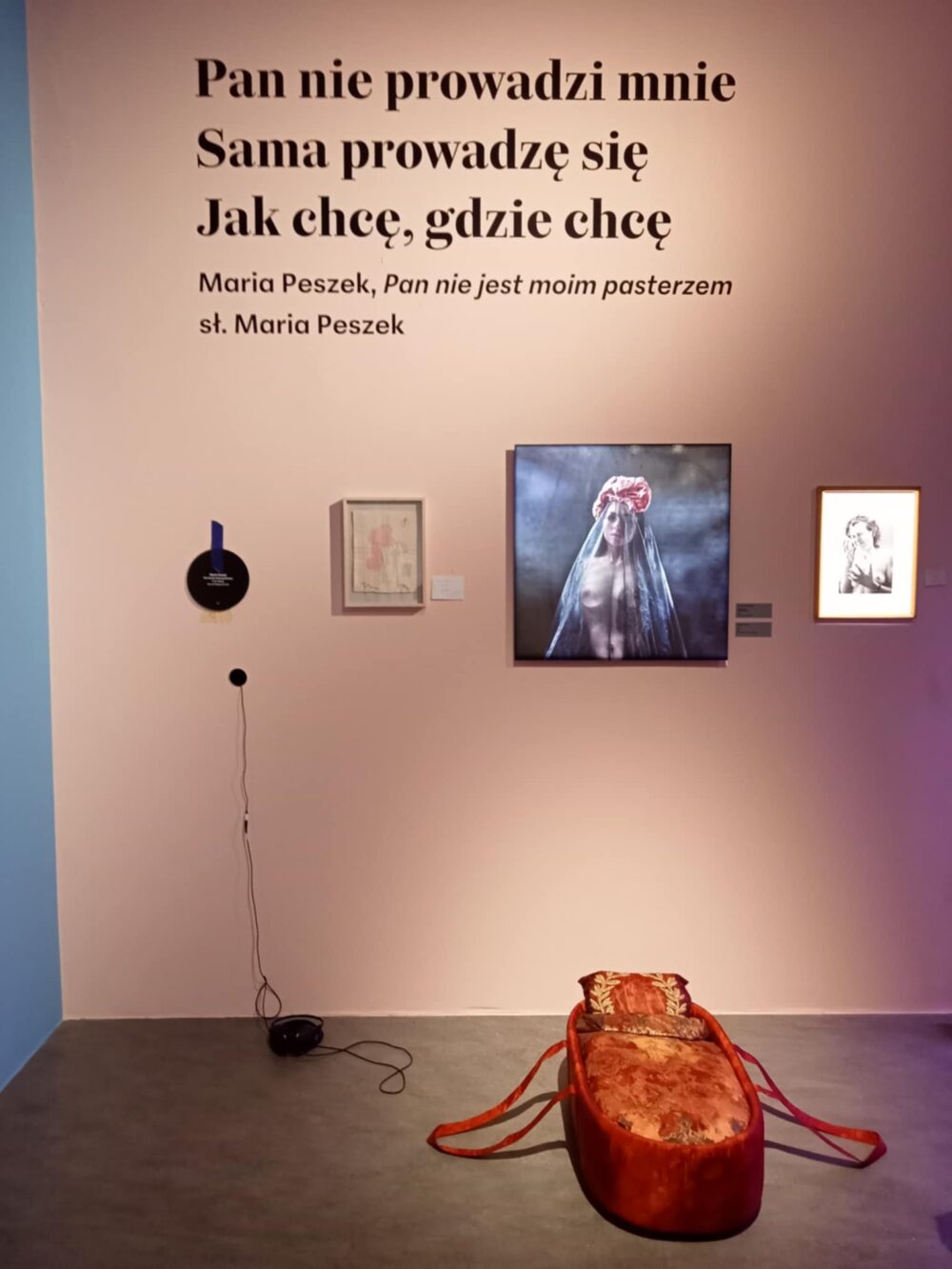 Praca Królowa Kier na wystawie w Centrum Sztuki Współczesnej w Toruniu, zawieszona na białej ścianie w towarzystwie innych dzieł.